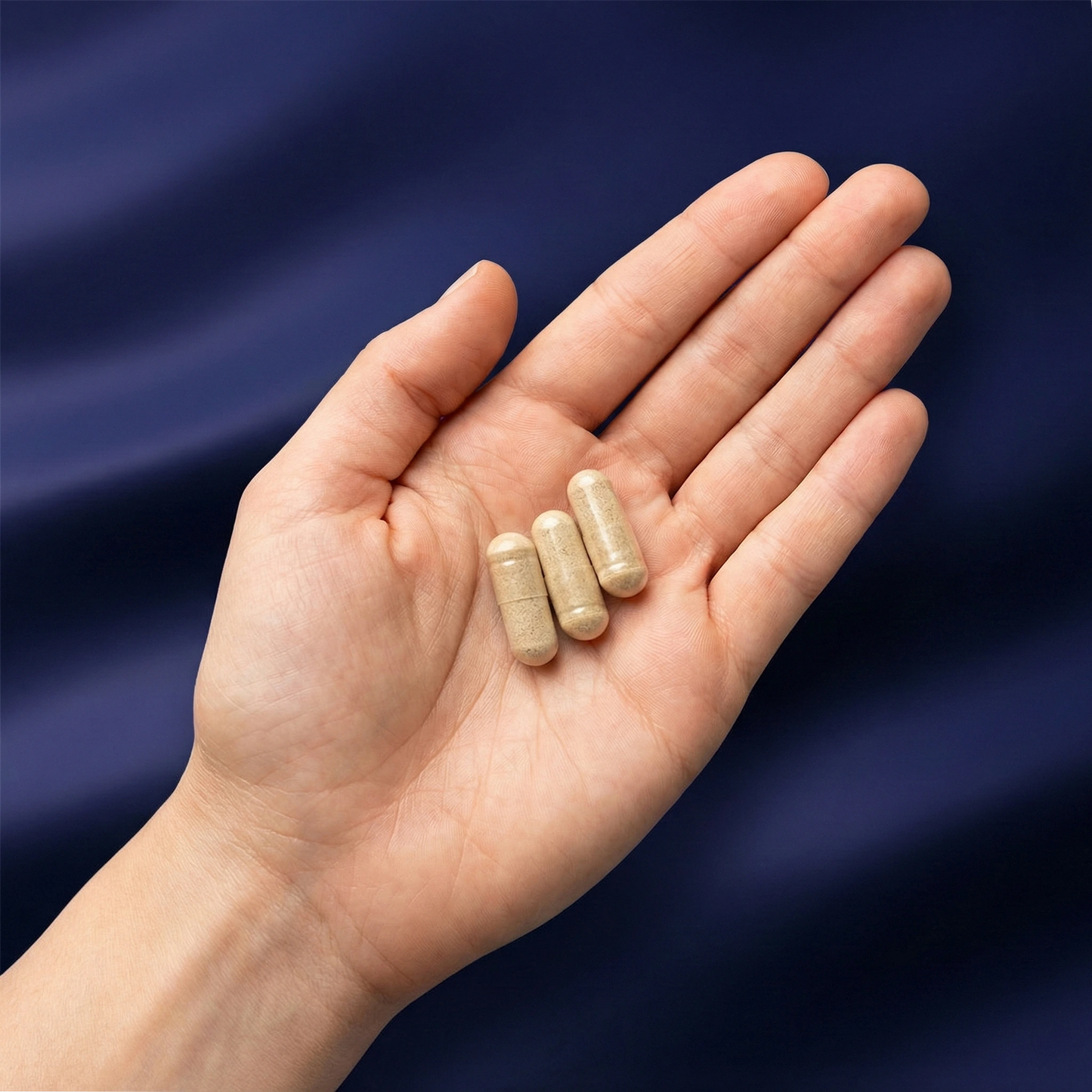 Illustration d'une main contenant " gélules correspondant aux trois ingrédients de la cure rythme soutenu Aqila Nutrition